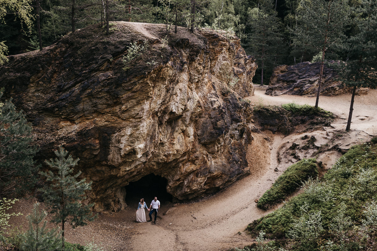 Para mloda stojaca na skraju jaskini w gorach